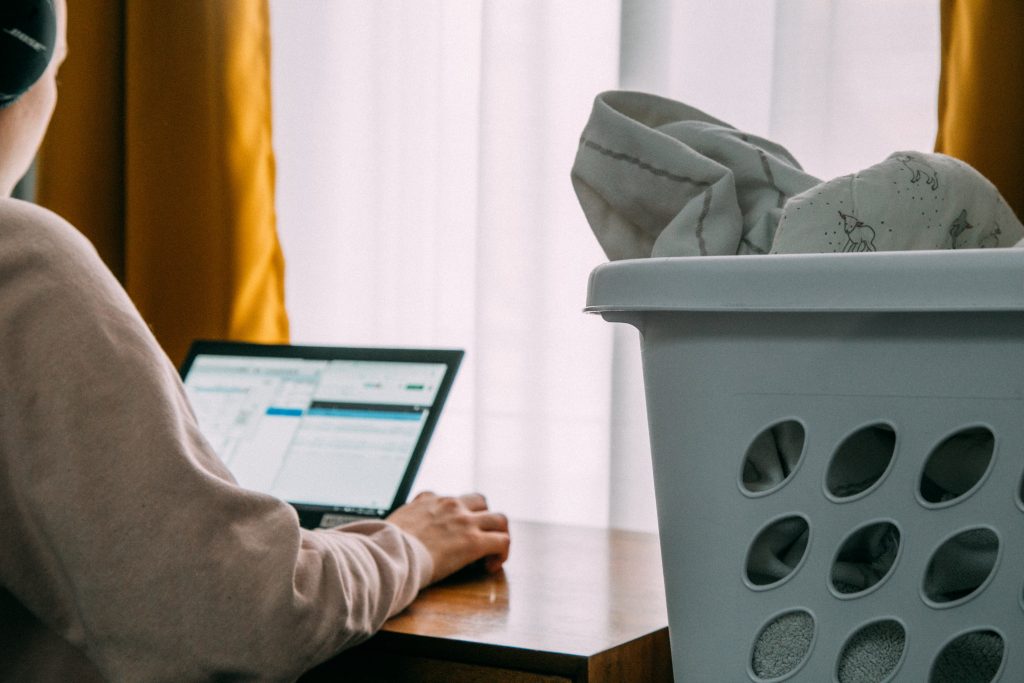 Laundry basket by woman on computer looking for a job, Platinum Resumes, Kansas City, MO