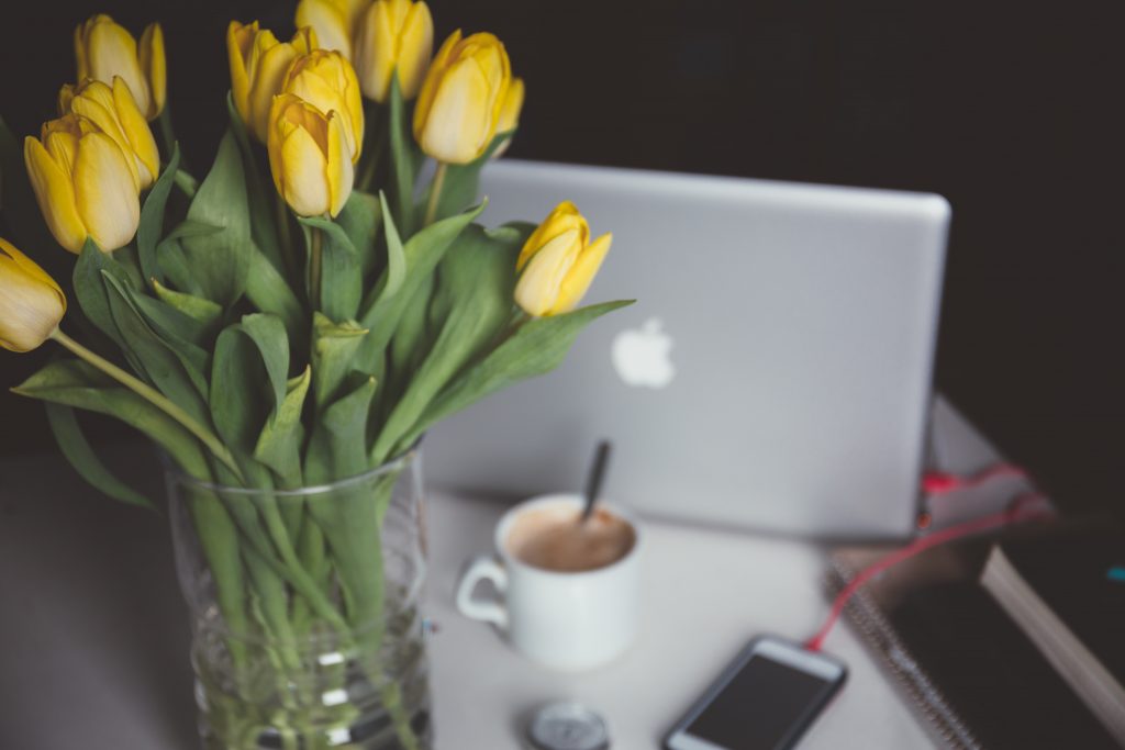 Laptop by vase of yellow tulips, Platinum Resumes, Kansas City, MO