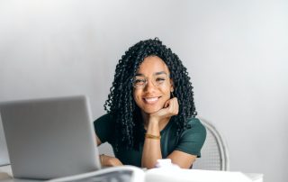 Woman smiling at laptop, Platinum Resumes, Kansas City, MO