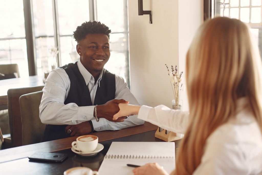 Man interviewing with woman, shaking hands, Platinum Resumes, Kansas City, MO