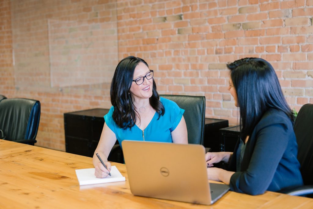 2 women discussing their resumes at table with laptop, Platinum Resumes, Kansas City, MO