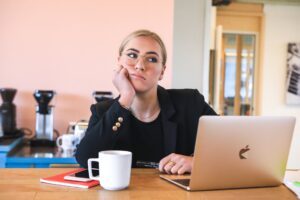 Younger girl in glasses looking pensive in front of laptop, Platinum Resumes, Kansas City, MO