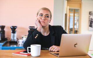 Younger girl in glasses looking pensive in front of laptop, Platinum Resumes, Kansas City, MO