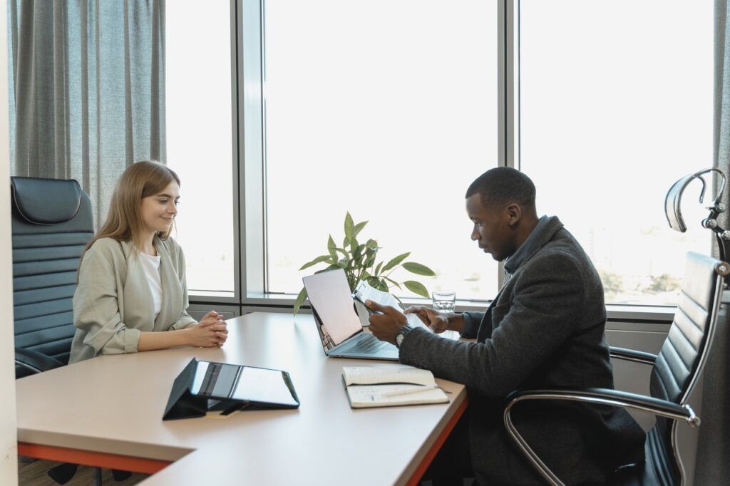 2 people at a desk interviewing, Man taking notes talking to man with name tag, Platinum Resumes, Kansas City, MO