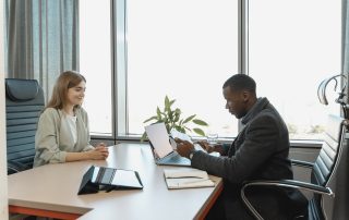 2 people at a desk interviewing, Man taking notes talking to man with name tag, Platinum Resumes, Kansas City, MO